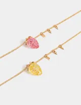Set de dos collares dorados con dije de frutilla transparente con glitter, uno rosado y otro amarillo.
