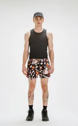 Short de baño negro con estampado abstracto en tonos naranja, rosa y blanco.