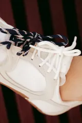 Zapatillas urbanas de cuero color tostado, con cordones verdes y suela de goma.