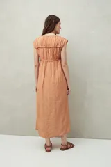 Vestido largo lila con escote con lazo, mangas cortas y frunces en el pecho.