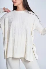 Sweater negro de punto con diseño de ochos, cuello redondo y mangas largas.