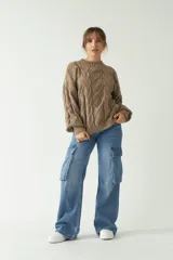 Sweater marrón de punto trenzado con cuello redondo y mangas largas abullonadas.