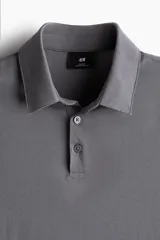 Remera polo gris de piqué liviano de mezcla de algodón, manga corta, cuello clásico y tapeta de botones. Corte ajustado. Confeccionada con tejido funcional COOLMAX®, una fibra exclusiva de poliéster de secado rápido que elimina la humedad y regula la temperatura corporal.