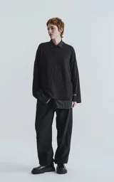 Sweater negro de punto con cuello polo y corte oversize.