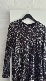 Minivestido negro con lentejuelas y estampado geométrico blanco.