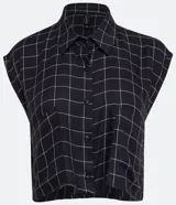 Blusa cropped musculosa de viscosa con estampado de cuadros, cuello camisero y abotonadura frontal.