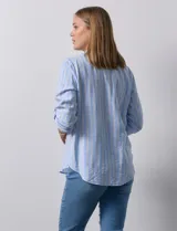 Blusa beige con rayas verticales blancas, escote en V y mangas 3/4 regulables con presilla y botón.