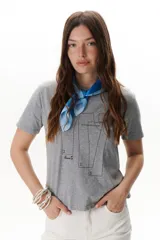 Remera blanca de algodón con cuello redondo y estampado de patrones de costura en el frente.