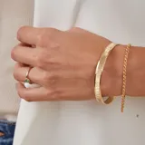 Pulsera rígida dorada con textura satinada y otra con textura martillada.