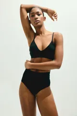 Bombacha de punto negra con efecto moldeador en la cintura. Modelo de tiro alto con refuerzo interior y cobertura media en la parte de atrás. Diseñada con el mínimo de costuras para una sensación suave y mínima visibilidad bajo la ropa.