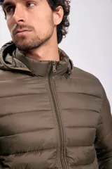 Campera capitoneada color verde con capucha y cierre frontal. Diseño acolchado y bolsillos laterales con cierre.