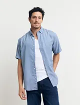 Camisa celeste con microestampado geométrico, de corte clásico, manga corta, cuello abotonado y bolsillo en el pecho.