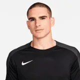 Remera deportiva Nike Strike de hombre, color negro con detalles en gris en los hombros y logo blanco en el pecho.