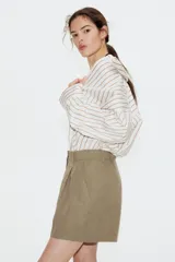 Short color arena de tiro alto, con pinzas delanteras, bolsillos laterales y presillas para cinturón.