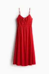 Vestido midi rojo de punto con efecto arrugado, breteles spaghetti ajustables, escote corazón con abertura de cerradura y tiras finas para atar en el busto. Elástico fino bajo el busto y falda con leve vuelo.