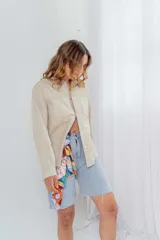 Camisa color avellana de cuero ovino italiano, de corte recto, con cuello camisero, cierre frontal con botones a presión y bolsillo de parche en el pecho.