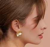 Aros tipo caravana dorados con forma de hoja de camelia.