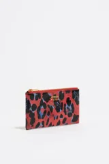 Monedero de tamaño grande con estructura rígida y exterior con textura brillante, estampado animal print en tonos rojo, negro y azul. Cuenta con cierre de cremallera dorado, logo metálico de Bimba y Lola y tarjetero interior.