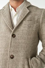 Abrigo masculino Don Baez confeccionado en lana sin teñir, con cuello con solapa, manga larga y forro. Tiene bolsillos y cierre frontal con botones.