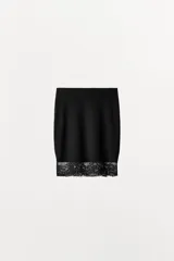 Falda corta negra, de tiro bajo y cintura elástica. El bajo está acabado con una aplicación de encaje negro a tono.