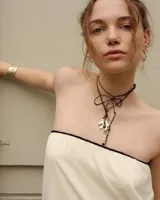 Collar con dije de bronce macizo con forma orgánica o de coral, suspendido de un hilo de seda natural color naranja.