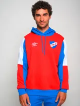 Buzo hoodie de fútbol Umbro del Club Nacional de Football. Diseño con bloques de color rojo, blanco y azul. Incluye logo de Umbro y escudo del club en el frente.