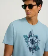 Remera celeste de algodón con cuello redondo y manga corta. Estampa de rosa de los vientos en acuarela en el frente.