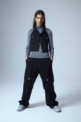 Pantalón cargo de denim negro, con cintura elástica y grandes bolsillos cargo a los lados con botones metálicos plateados.