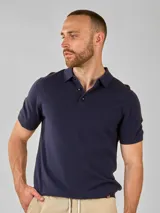 Remera de manga corta color azul marino, con cuello polo y tapeta de botones. Tejido de punto liso.