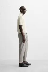 Pantalón de vestir gris oscuro, corte slim fit, con bolsillos laterales y traseros con botón.