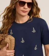 Blusa azul marino de algodón con cuello redondo y mangas cortas. Presenta bordados de barcos de vela en la parte delantera.
