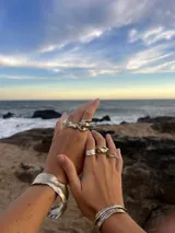 Brazalete rígido plateado con textura irregular.
