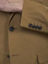 Blazer azul marino de corte clásico, con solapa de muesca, cierre de dos botones, bolsillo de parche en el pecho y bolsillos con solapa en los laterales.