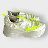 Championes blancos con plataforma, cordones y detalles en amarillo neón.