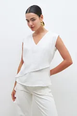 Blusa color crudo sin mangas con volado.