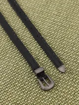 Cinturón negro de cuero vacuno con hebilla metálica plateada estilo western y puntera metálica.
