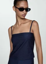 Top azul de jean con breteles finos y escote recto.