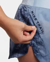 Short de running Nike Trail, color celeste con estampado abstracto en azul y gris. Cuenta con tecnología repelente al agua, cintura elástica con cordón ajustable, tres bolsillos internos y un bolsillo con cierre en el muslo derecho.