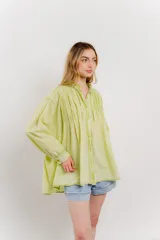Camisa oversize blanca de algodón con pliegues frontales.