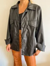 Camisa de eco cuero negro, con corte holgado y bolsillos en el pecho.