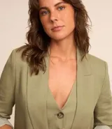 Blazer largo color beige confeccionado en viscosa y lino, con cuello solapa, bolsillos y forro estampado a rayas.