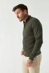 Sweater de punto negro con cuello alto y cierre parcial con cremallera.