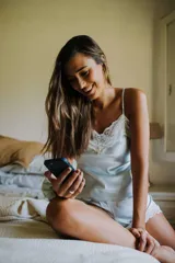 Conjunto de pijama celeste de satén, compuesto por un top de breteles finos con encaje blanco en el escote y un short con cintura elástica y encaje blanco en el ruedo.