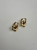 Par de aros dorados de acero quirúrgico hipoalergénico, tipo argolla con dije colgante en forma de estrella.