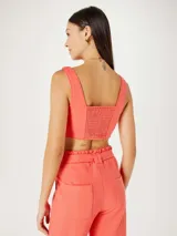 Top corto de tirantes anchos, color rosa pálido, con escote cuadrado.