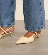 Zapato de tacón color crema, con punta fina, tira delantera y tira trasera con hebilla.