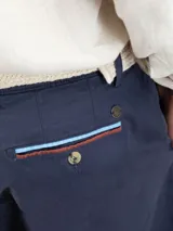 Bermuda de hombre color azul marino, marca El Ganso, de tejido 77% algodón, 20% algodón reciclado y 3% elastán. Corte Regular Fit. Tiene dos bolsillos laterales y bolsillos traseros con cintas insertadas. Tinte pigmentario consiguiendo un color desgastado.