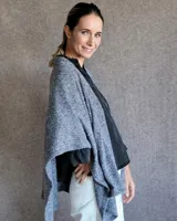 Ruana tejida en lana color gris claro, de corte amplio y diseño abierto.
