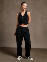 Pantalón negro de vestir con pinzas, corte holgado y tiro alto.