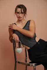 Body negro con escote redondo y apliques de strass plateados en el frente. Presenta corte cut-out en los laterales y cierre con lazos.